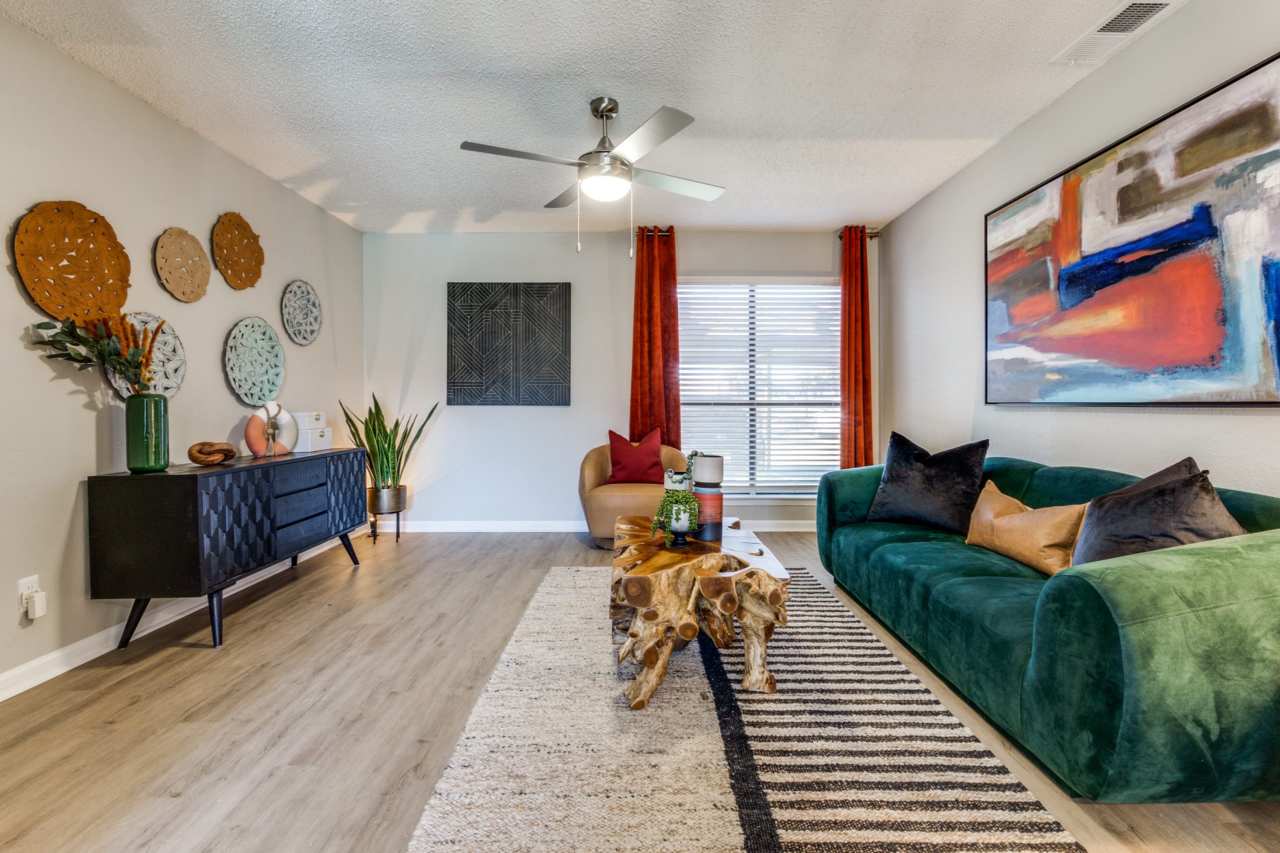 a living room with green furniture and a large painting at The Reid Apartments