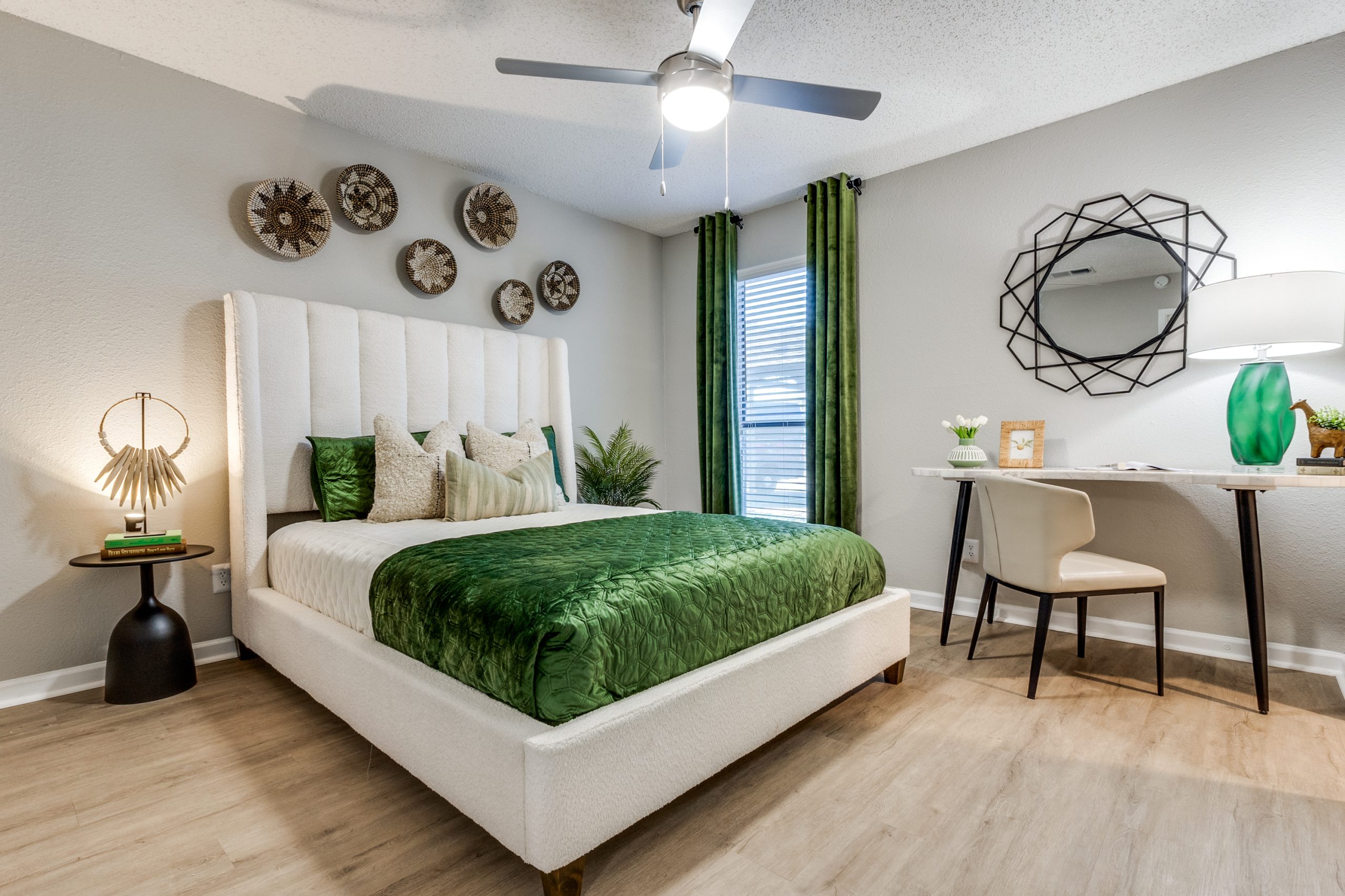 a bedroom with green accents and a white bed at The Reid Apartments
