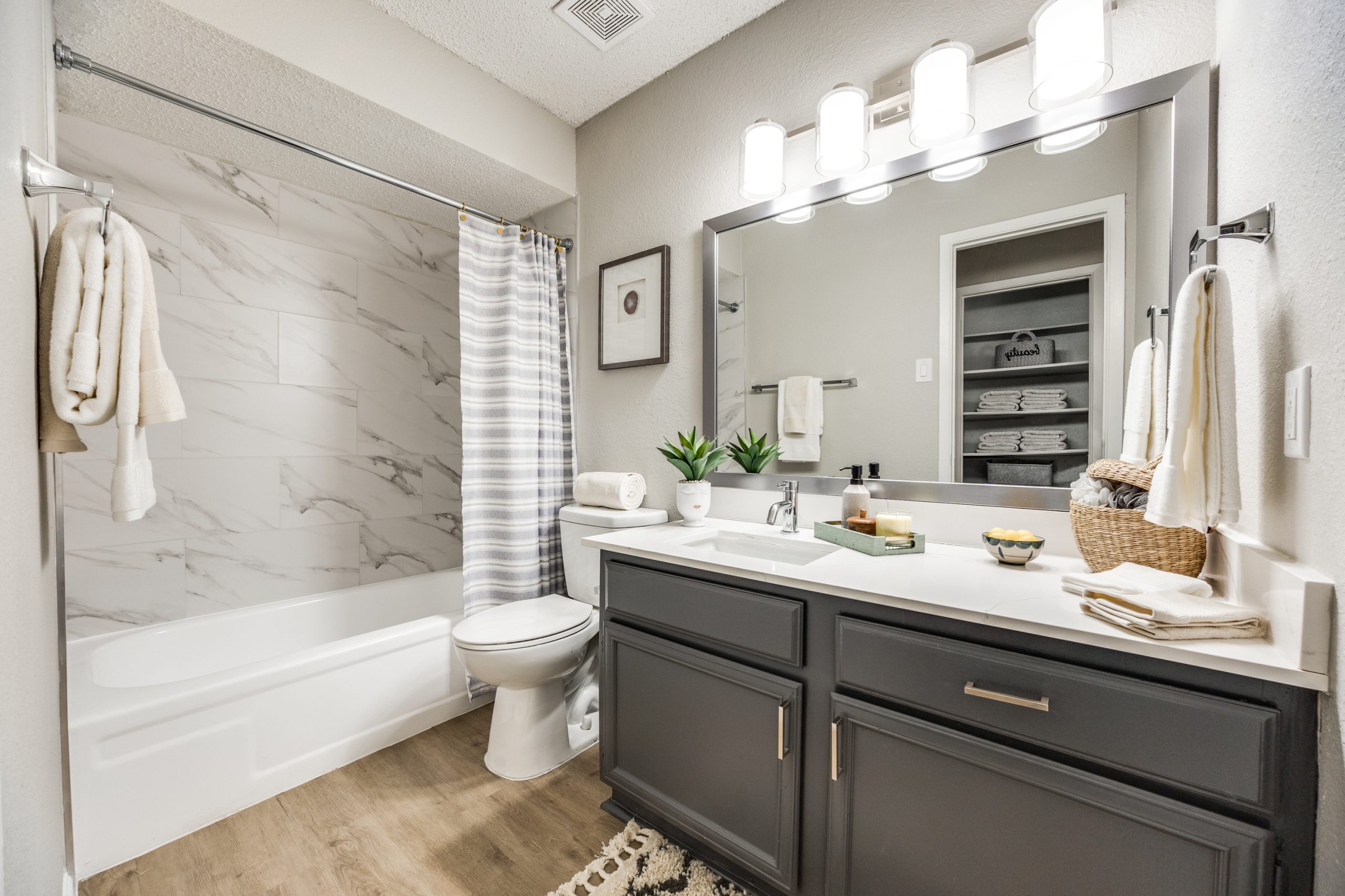 a bathroom with a white vanity and gray cabinets at The Reid Apartments
