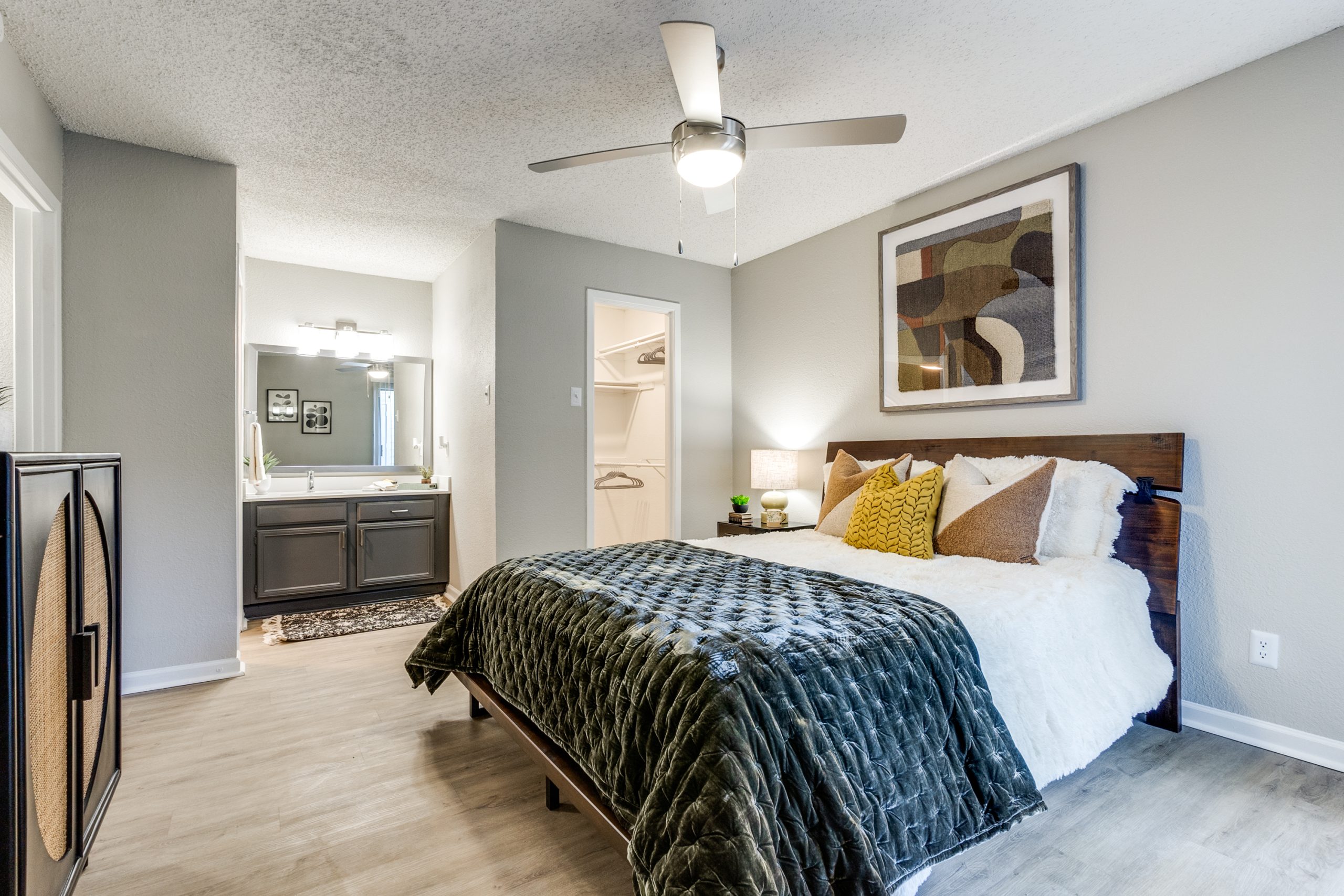 a bedroom with a ceiling fan and hardwood floors at The Reid Apartments
