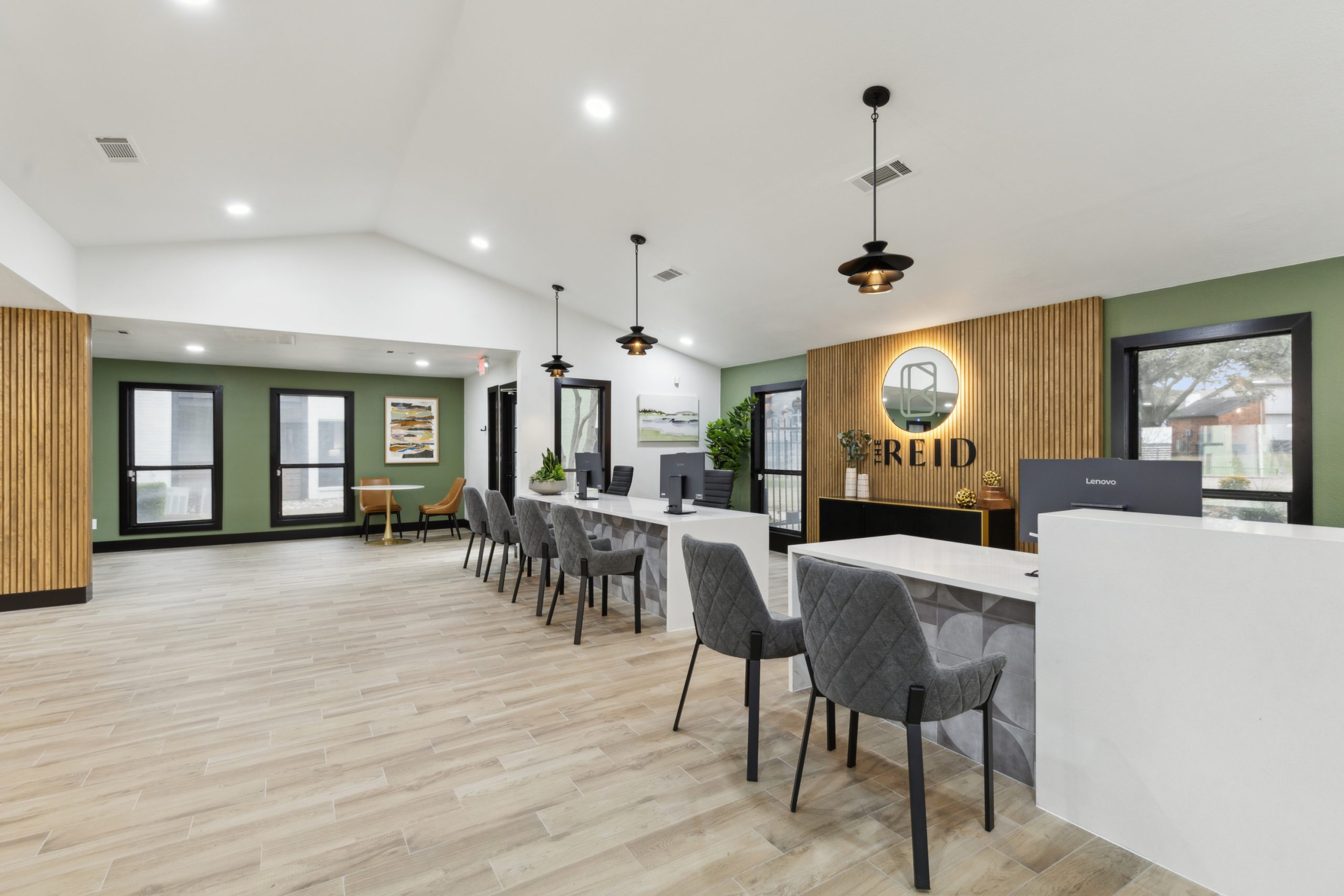 the lobby of a new apartment building with green walls and wood floors at The Reid Apartments